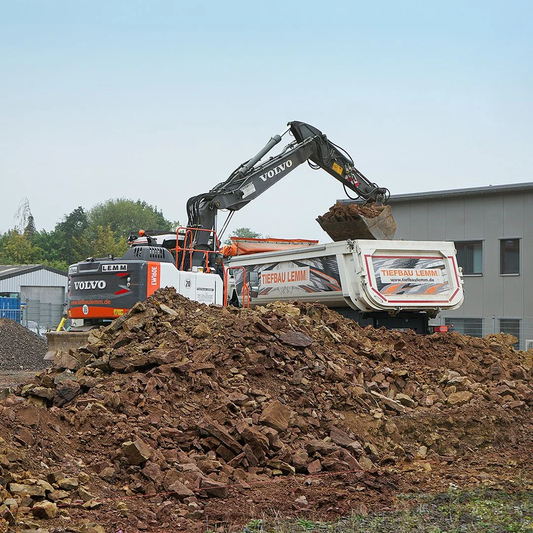 Bagger und Muldenkipper von Tiefbau LEMM bei den Erdarbeiten für die neue SETOLITE-Lagerhalle